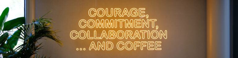 Neonkyltti toimistossa tekstillä Courage, Commitment, Collaboration and Coffee